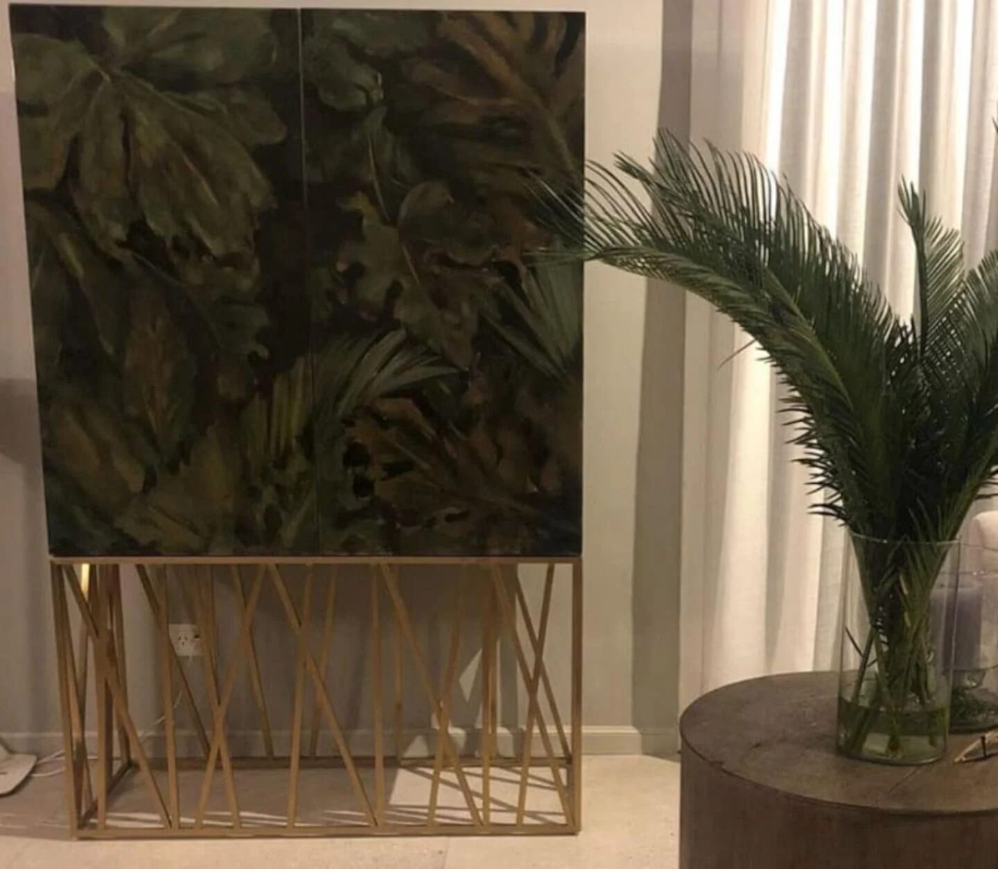 Mueble decorativo con diseño de hojas y planta en un ambiente acogedor