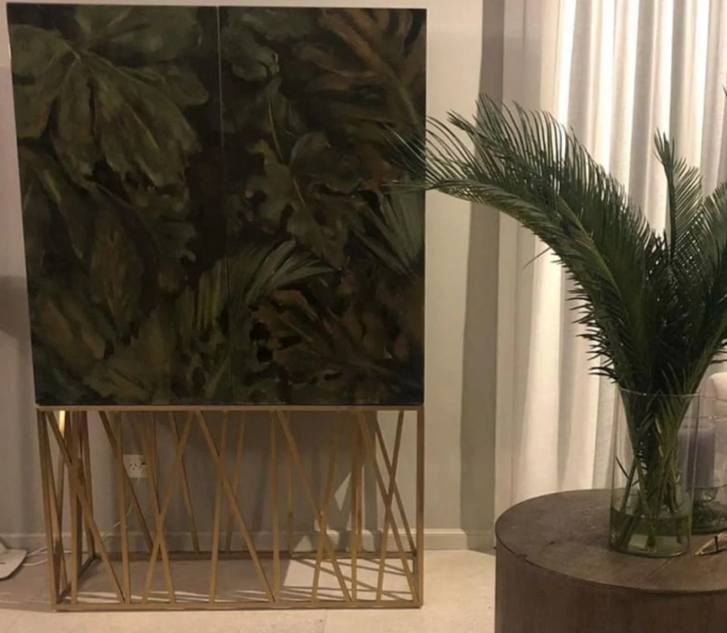 Mueble decorativo con diseño de hojas y planta en un ambiente acogedor