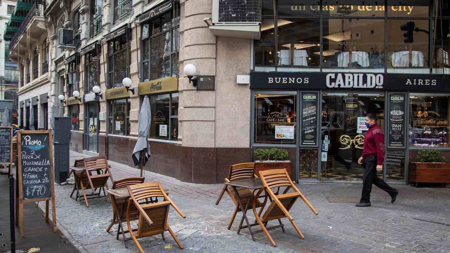 Exterior de un restaurante en Buenos Aires con sillas apiladas en la vereda