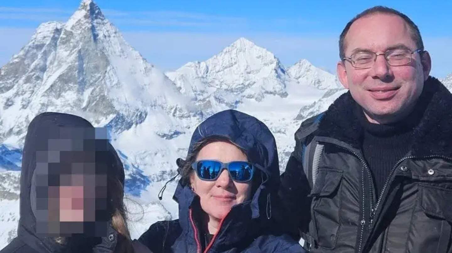 Familia en una montaña nevada con picos cubiertos de nieve de fondo