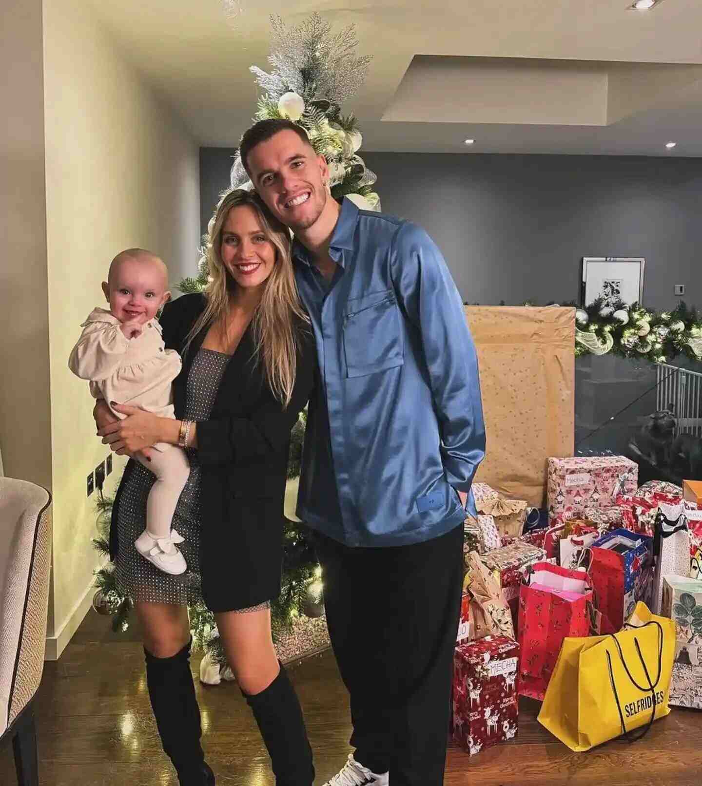 Giovani Lo Celso y Magui Alcácer posan junto a su hija frente a un árbol de Navidad decorado