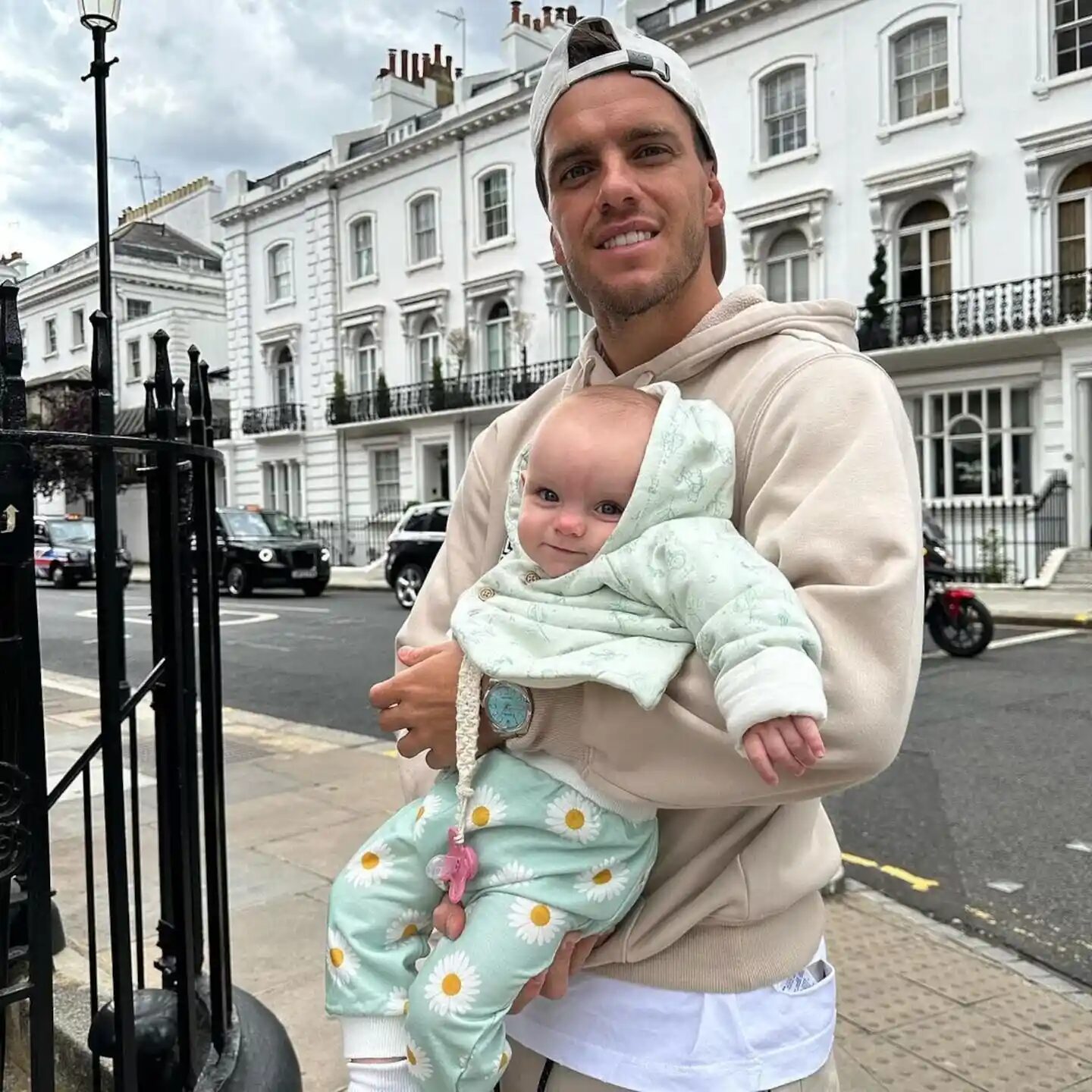 Giovani Lo Celso sosteniendo a su hija en una calle de Londres