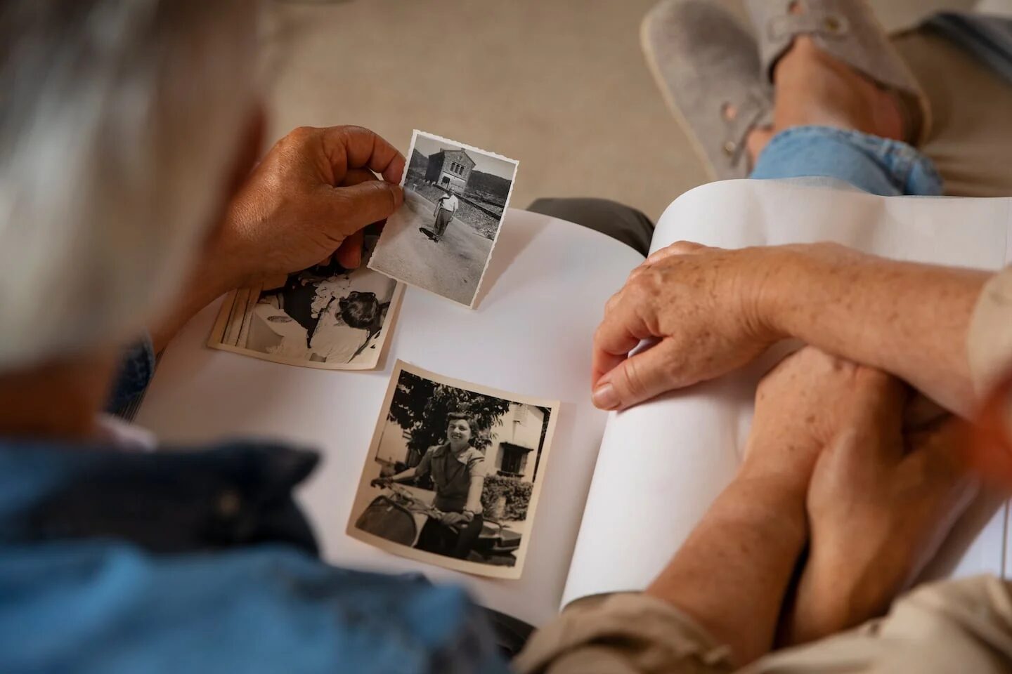 Personas mayores revisando fotografías familiares en un álbum