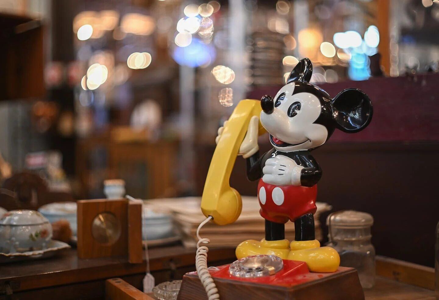 Teléfono antiguo con figura de Mickey Mouse en un ambiente vintage