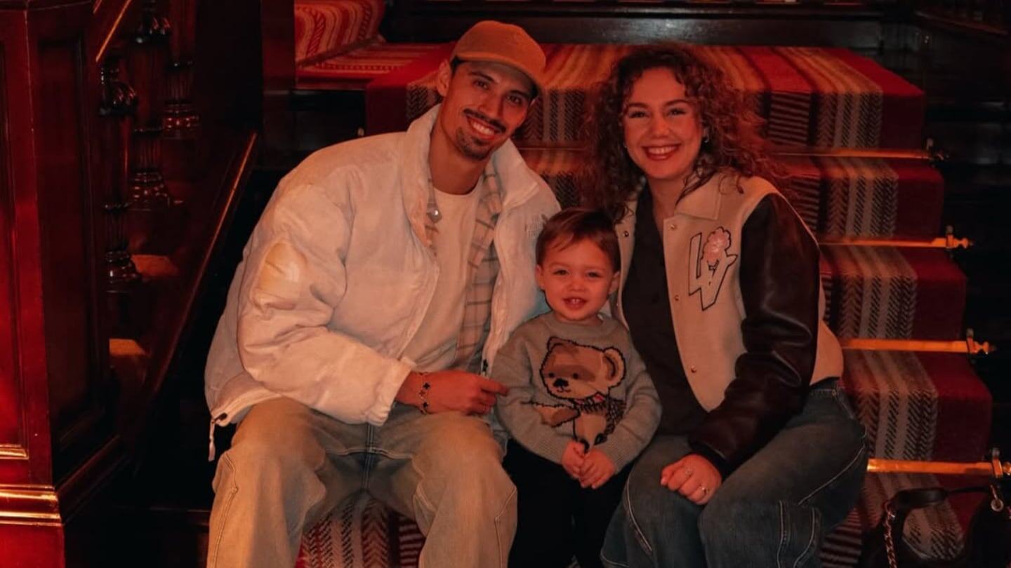 Tijjani Reijnders posando con su pareja y su hijo en una escalera decorativa