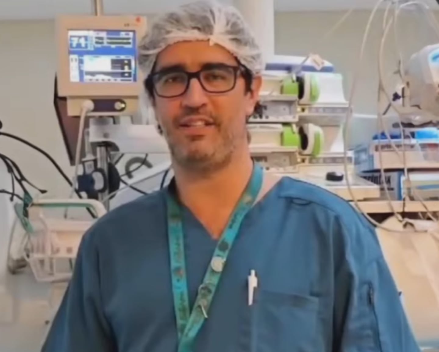 Médico en un entorno hospitalario con equipo médico detrás