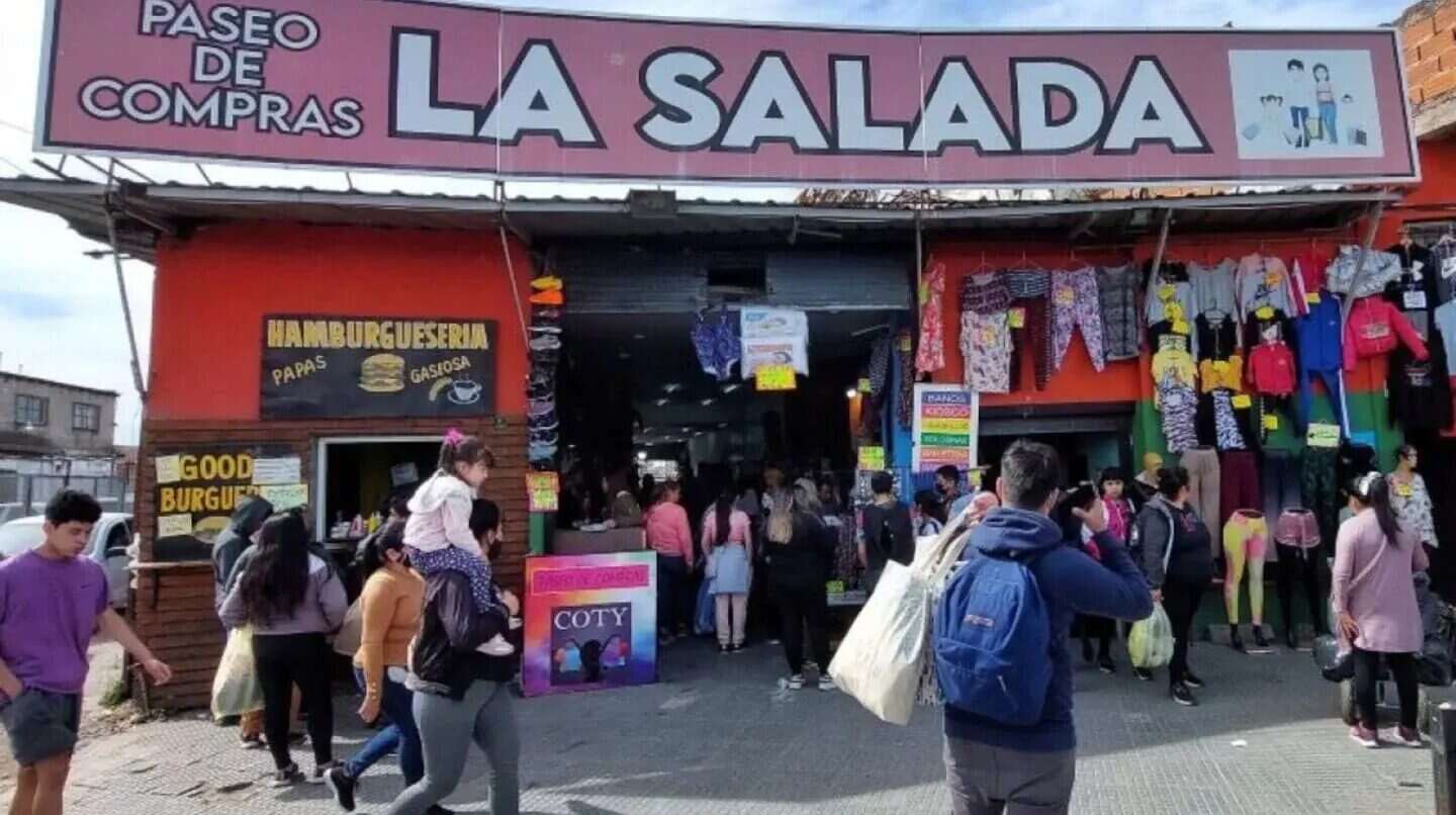 Vista del Paseo de Compras La Salada, con gente comprando y tiendas de ropa