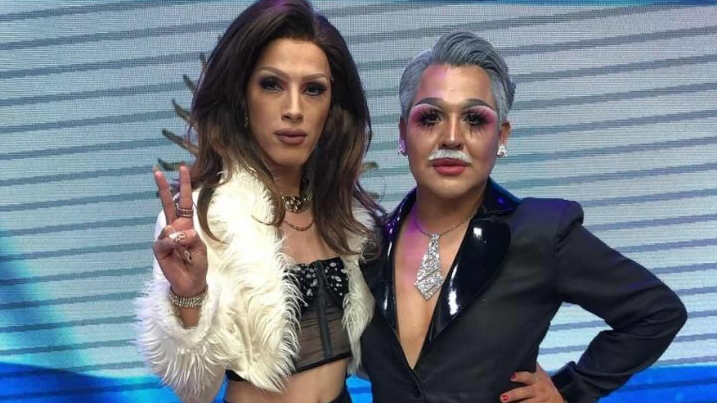 Dos drag queens posan juntas en un escenario colorido