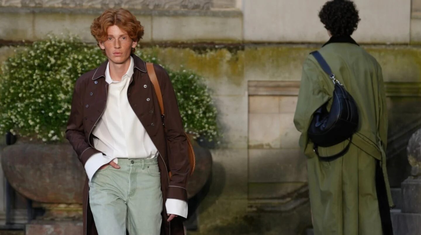 Modelo masculino con cabello rizado y abrigo marrón en la Semana de la Moda Masculina de París