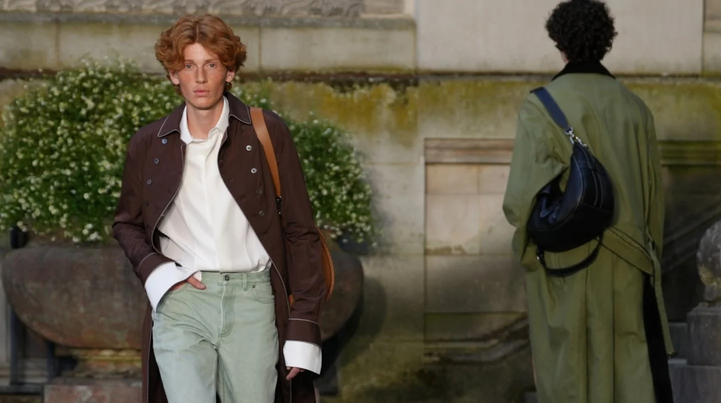 Modelo masculino con cabello rizado y abrigo marrón en la Semana de la Moda Masculina de París