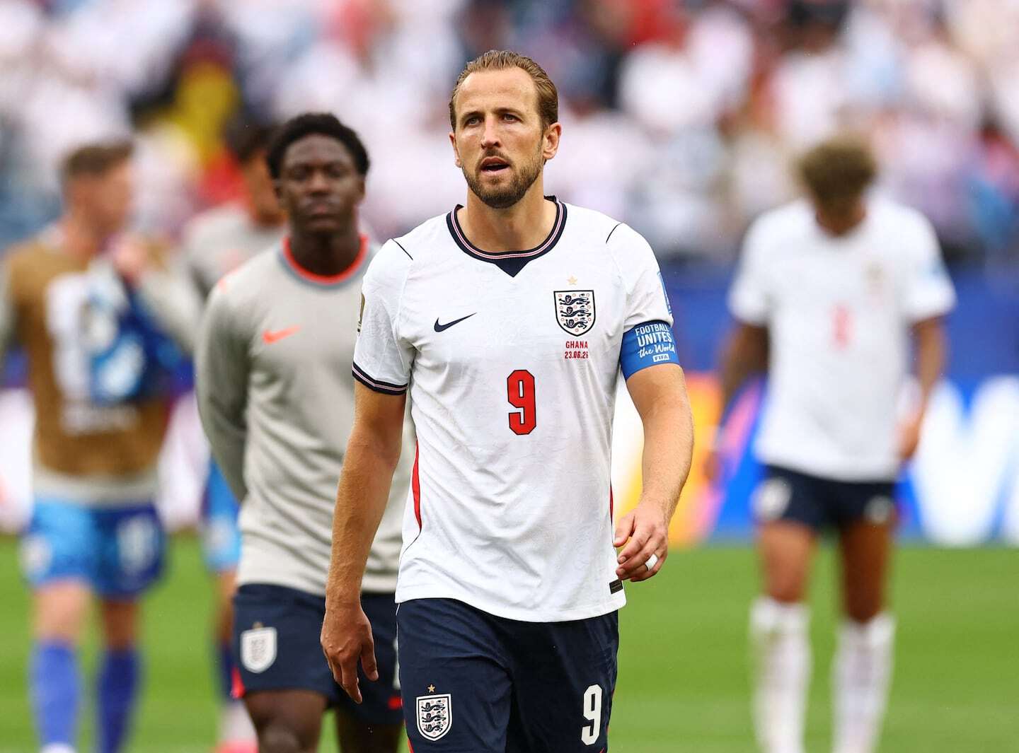 Harry Kane caminando con expresión seria durante un partido de fútbol con la selección de Inglaterra