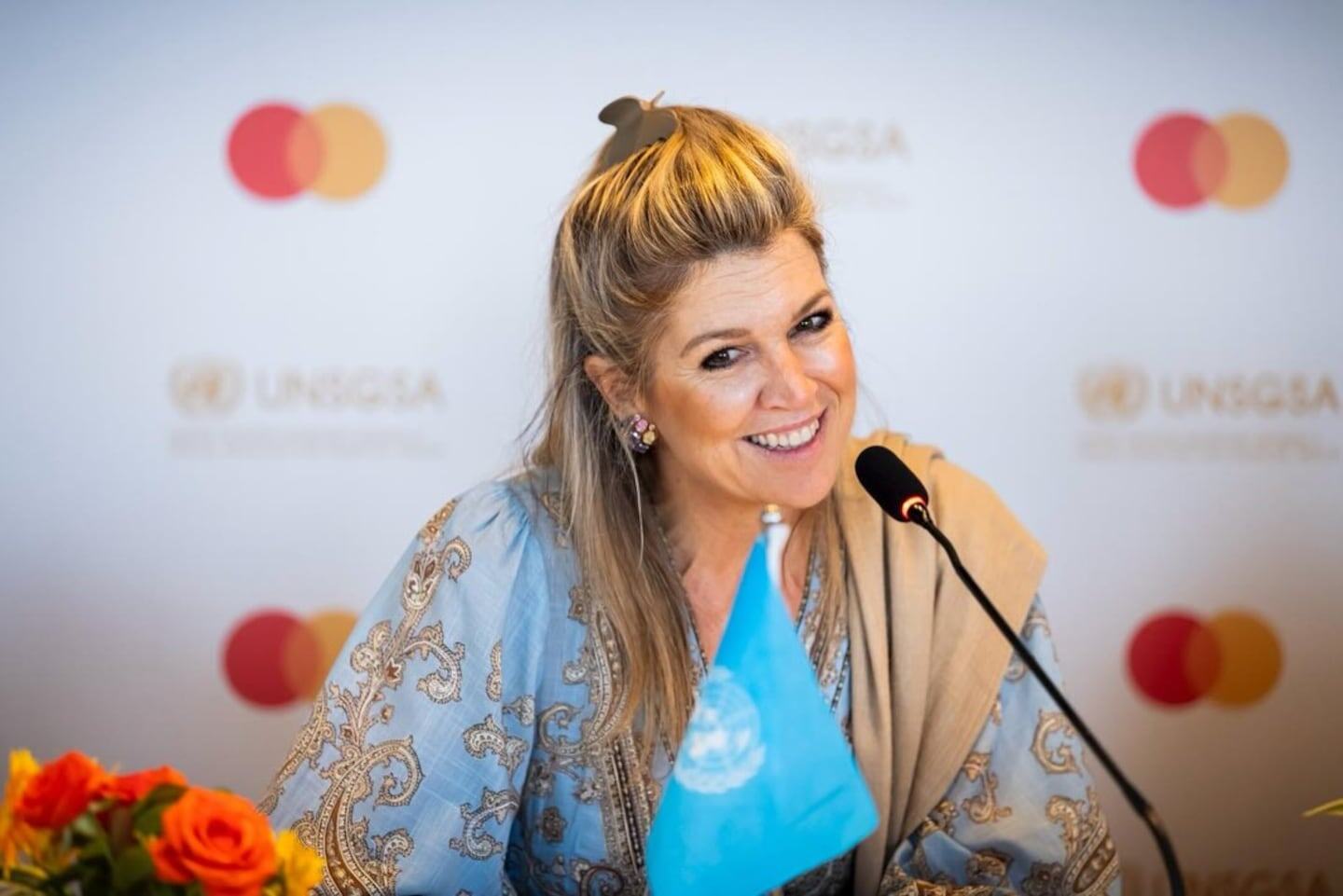 La reina Máxima de Holanda sonríe durante un evento en India con un vestido celeste y un bolso argentino