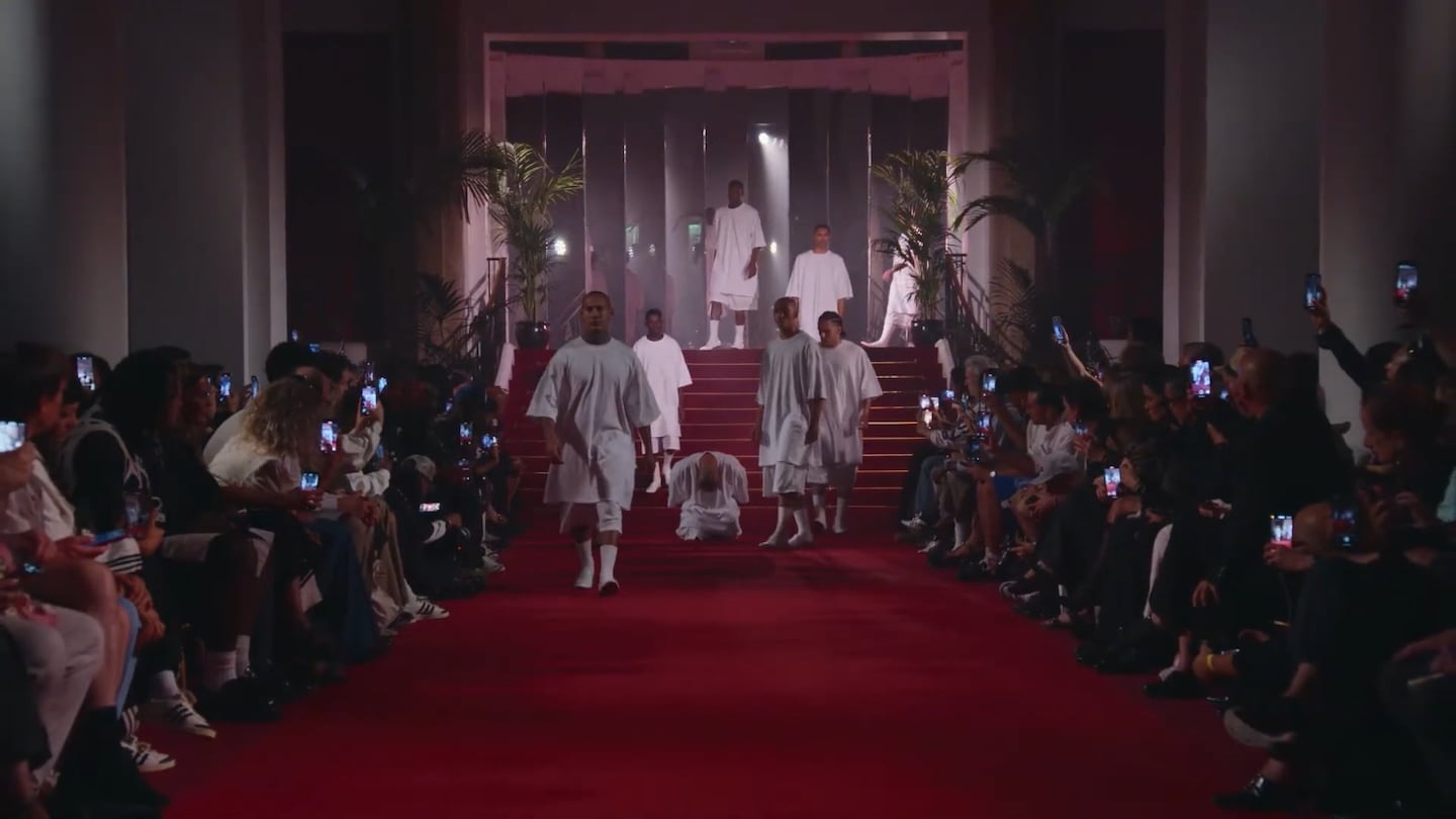 Modelos desfilando en la Semana de la Moda Masculina de París sobre una pasarela iluminada