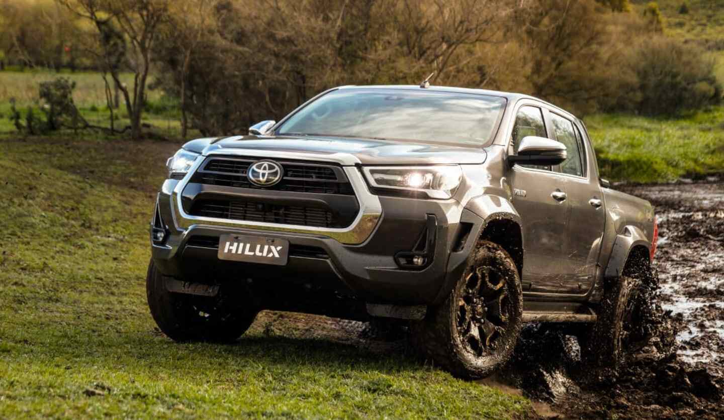 Toyota Hilux 4x4 atravesando un terreno fangoso en un paisaje natural