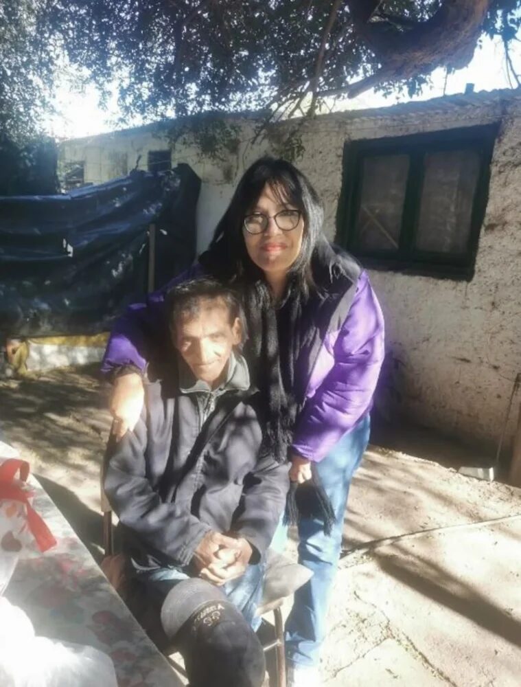 Nelson Madaf sentado junto a una mujer en un entorno exterior