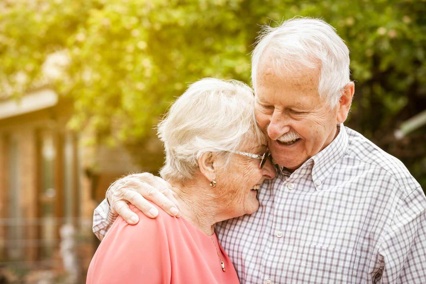 Pareja de ancianos sonriendo y abrazándose en un entorno natural