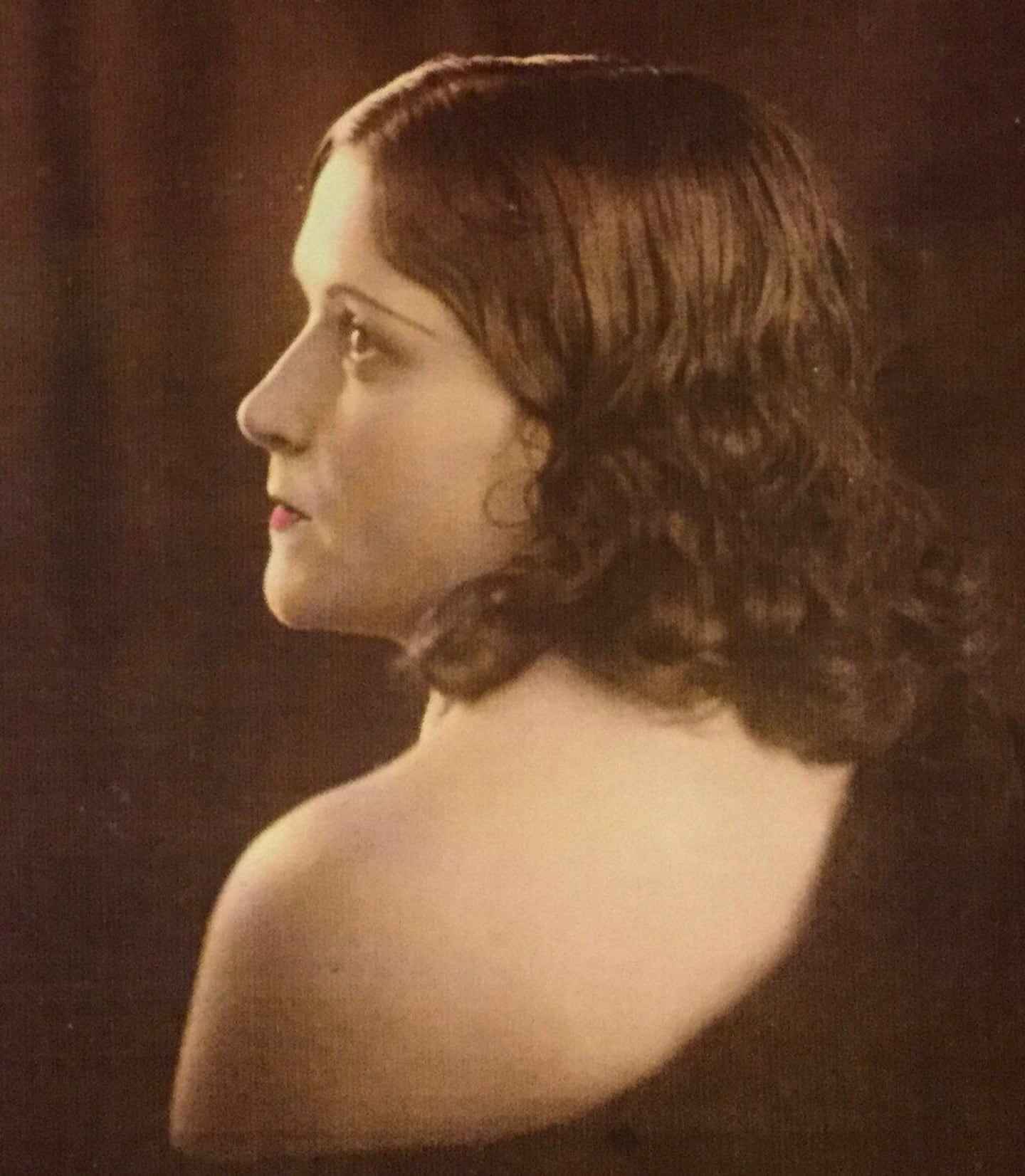 Retrato de una mujer con cabello ondulado y mirada pensativa