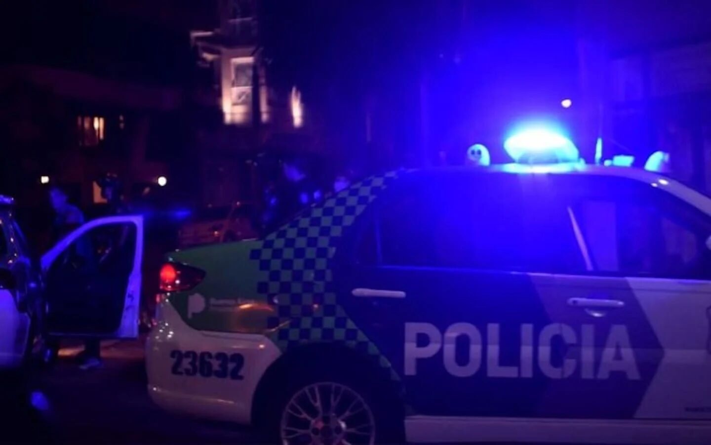 Vehículo policial con luces encendidas en una escena de crimen en Merlo
