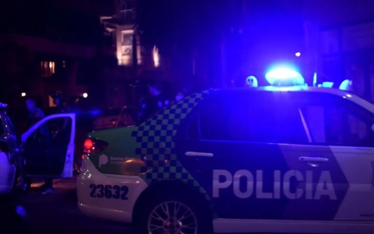 Vehículo policial con luces encendidas en una escena de crimen en Merlo