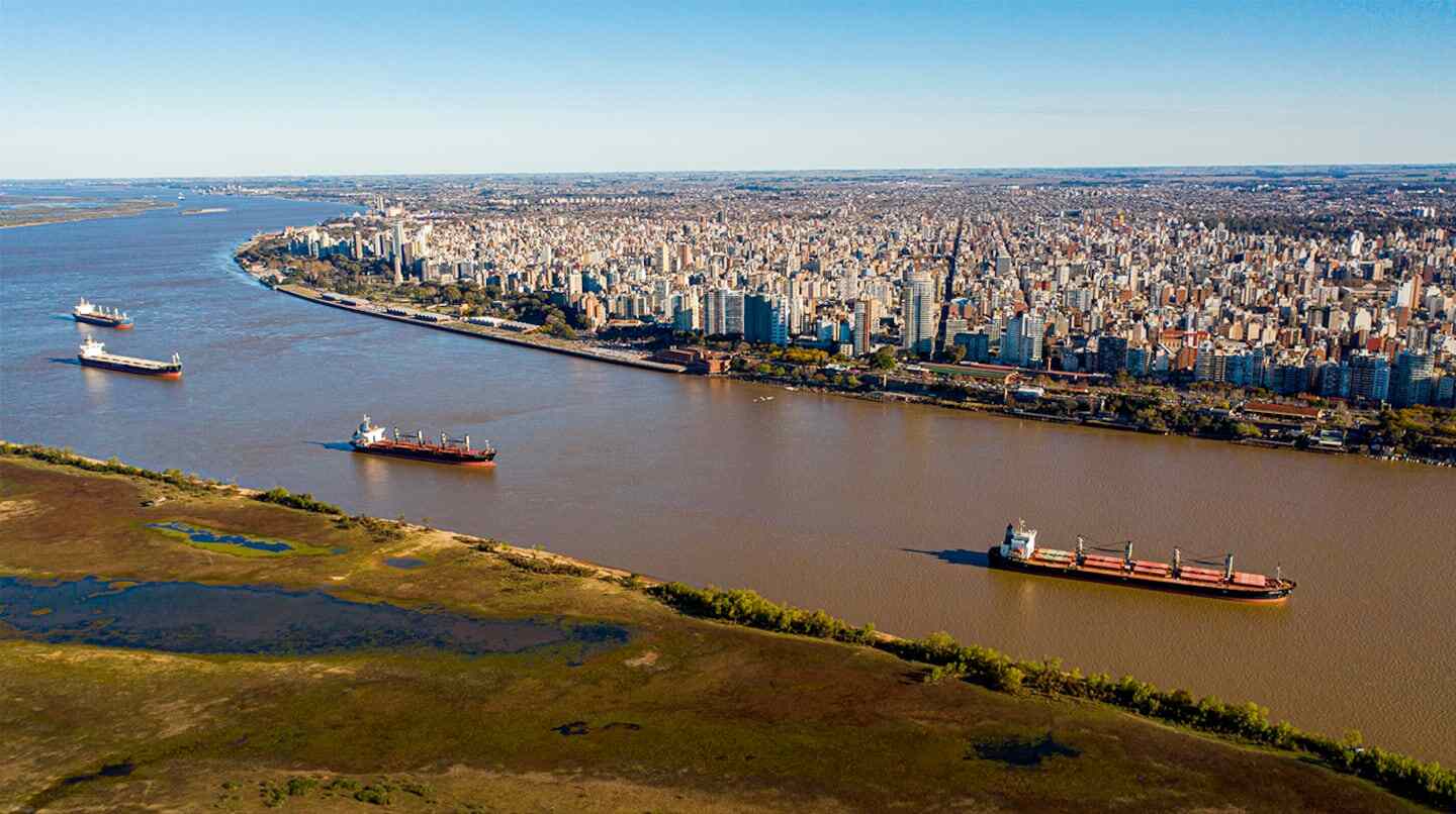 Vista aérea del puerto de una ciudad argentina con barcos de carga en el río