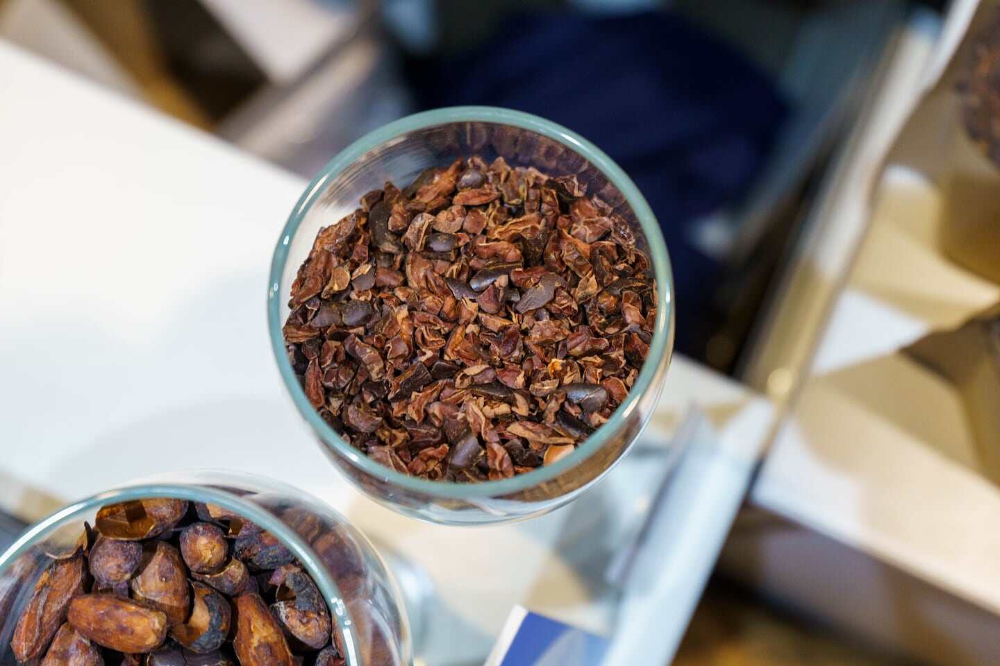 Granos de cacao tostados en un recipiente de vidrio