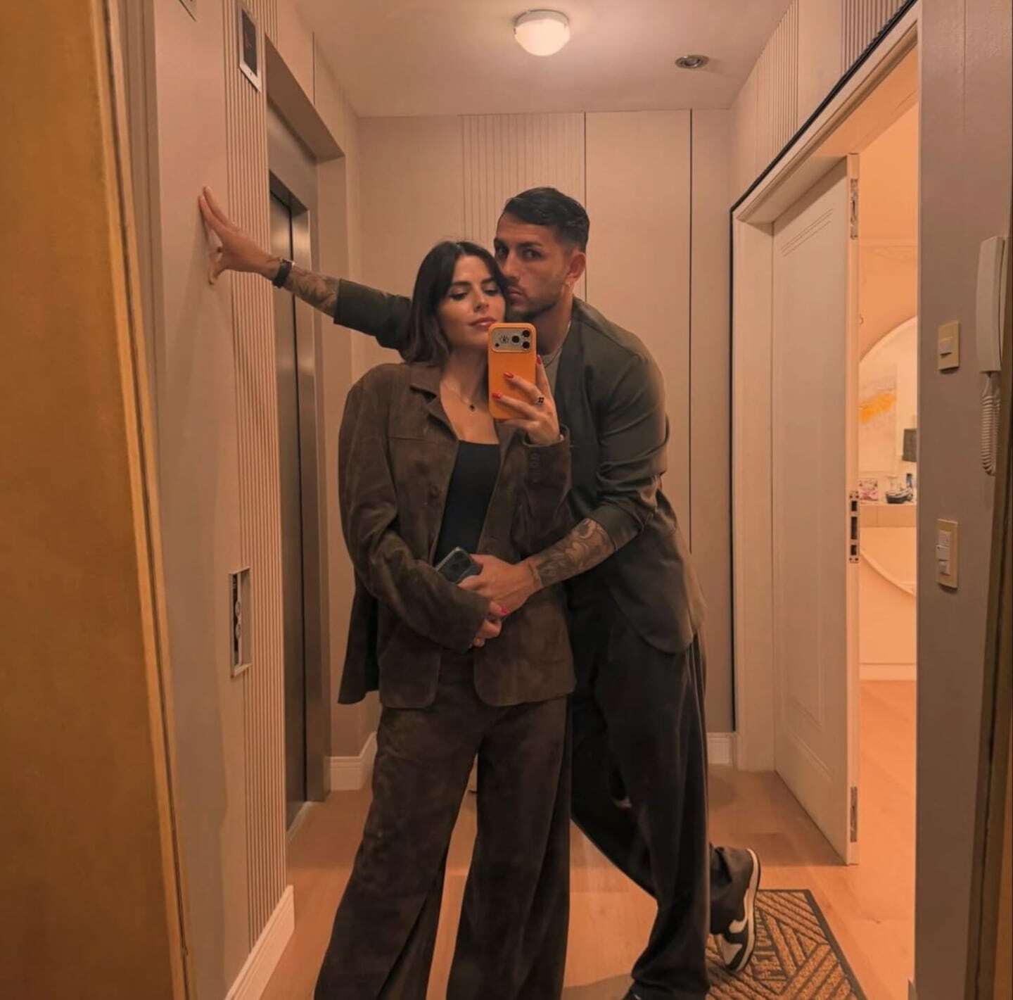 Leandro Paredes y Camila Galante posando juntos en un espejo con looks coordinados
