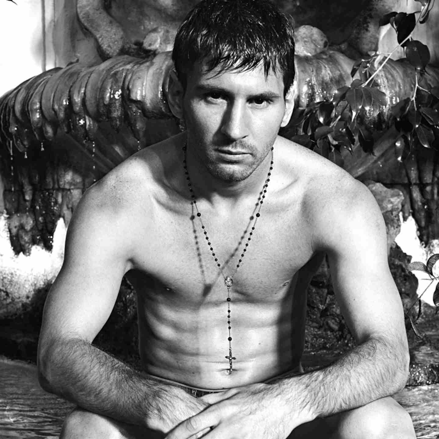 Lionel Messi posando sin camiseta con un rosario en un entorno natural