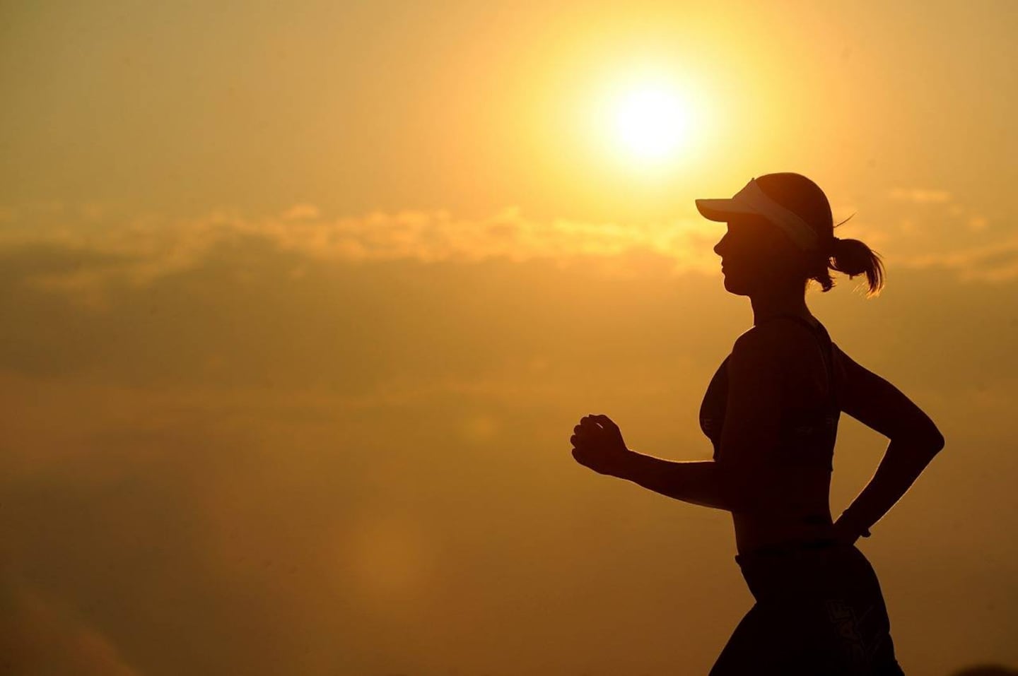 Silhouette de una mujer corriendo al atardecer