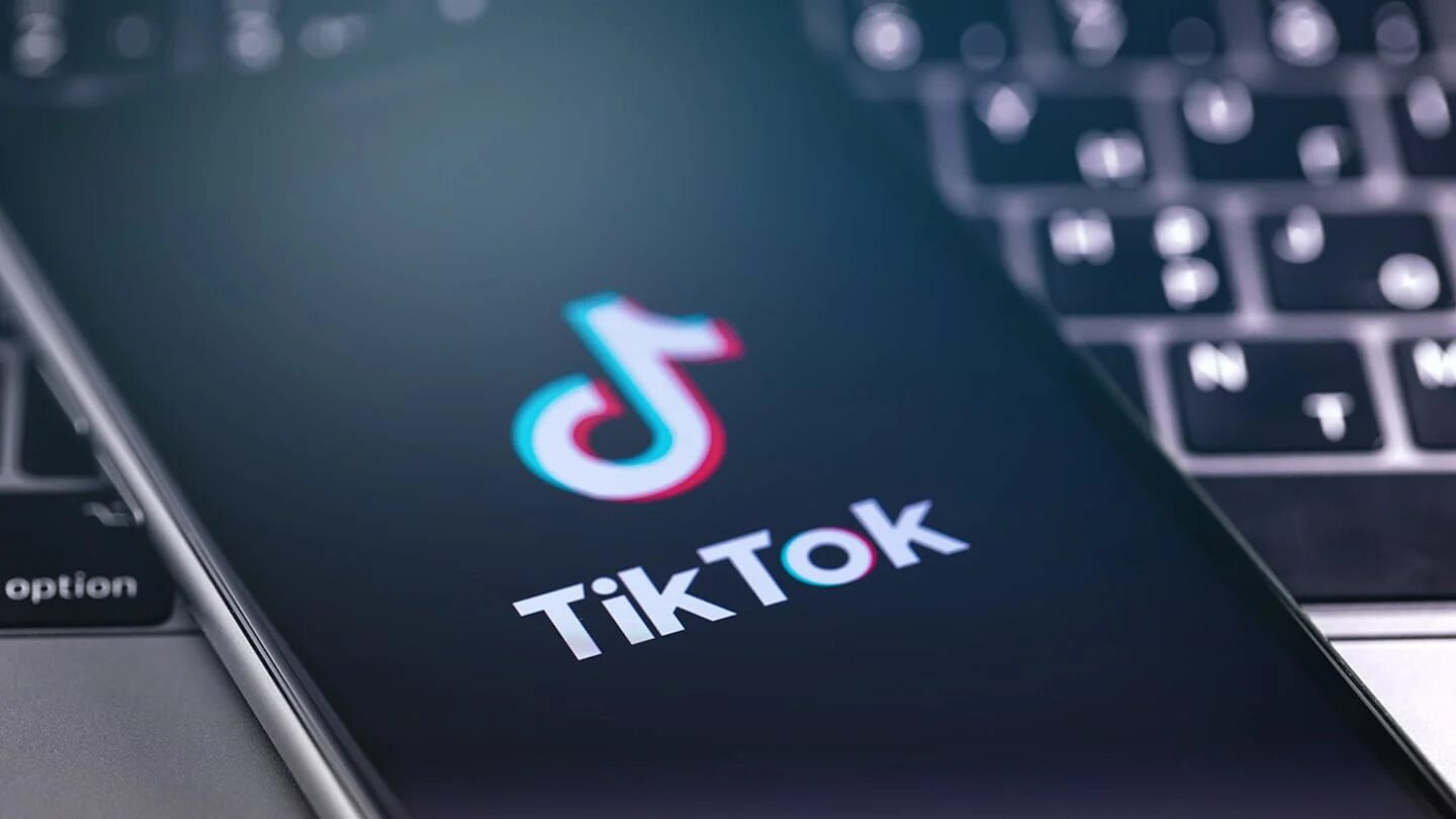 Logotipo de TikTok en un teléfono móvil sobre un teclado de computadora