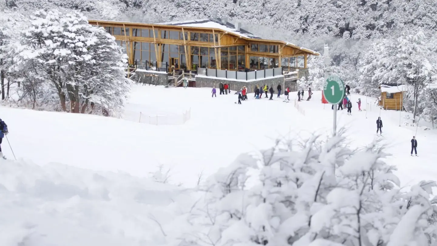 Esquiadores en una pista nevada cerca de un centro de esquí en Bariloche