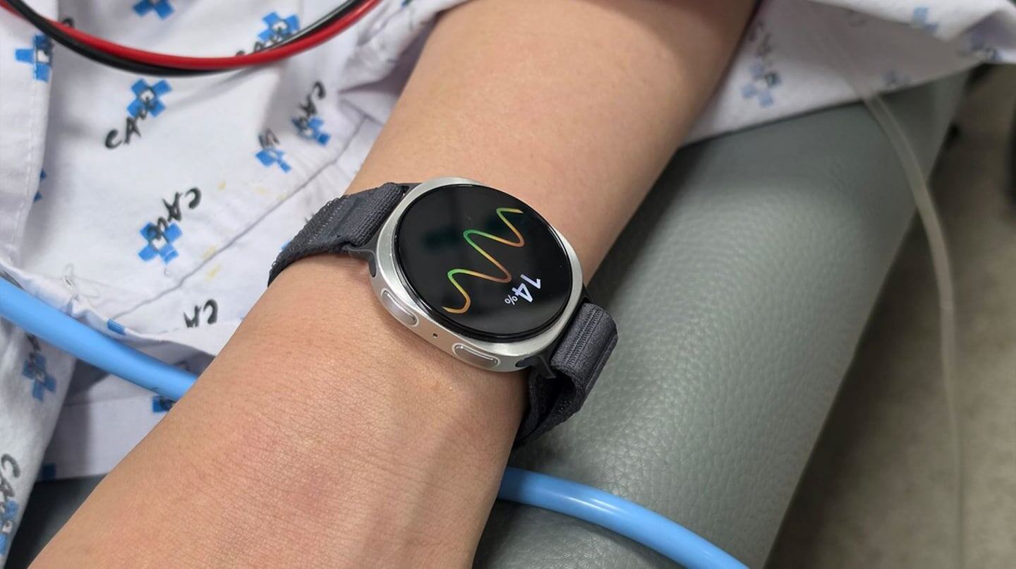 Reloj inteligente mostrando pulsaciones en una muñeca en un entorno médico