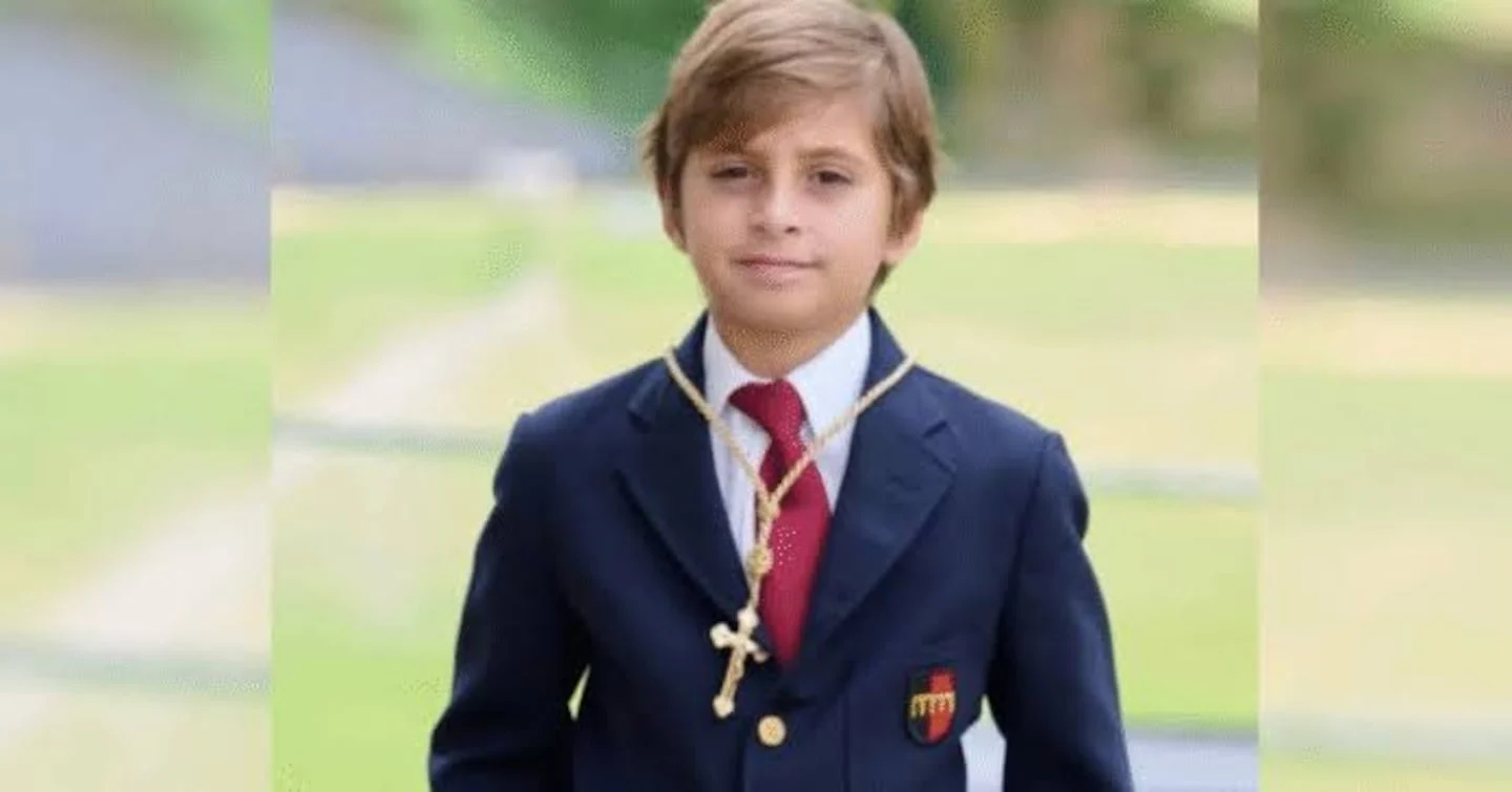 Lucas Gamez, niño argentino de 8 años, vestido con traje formal y cruz al cuello