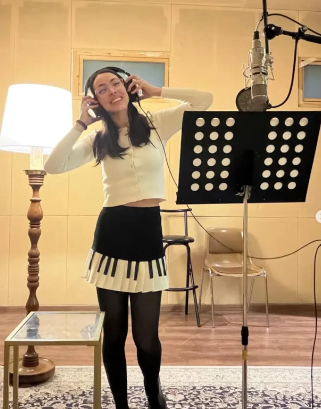 Luli Pampín en un estudio de grabación, sonriendo mientras usa auriculares