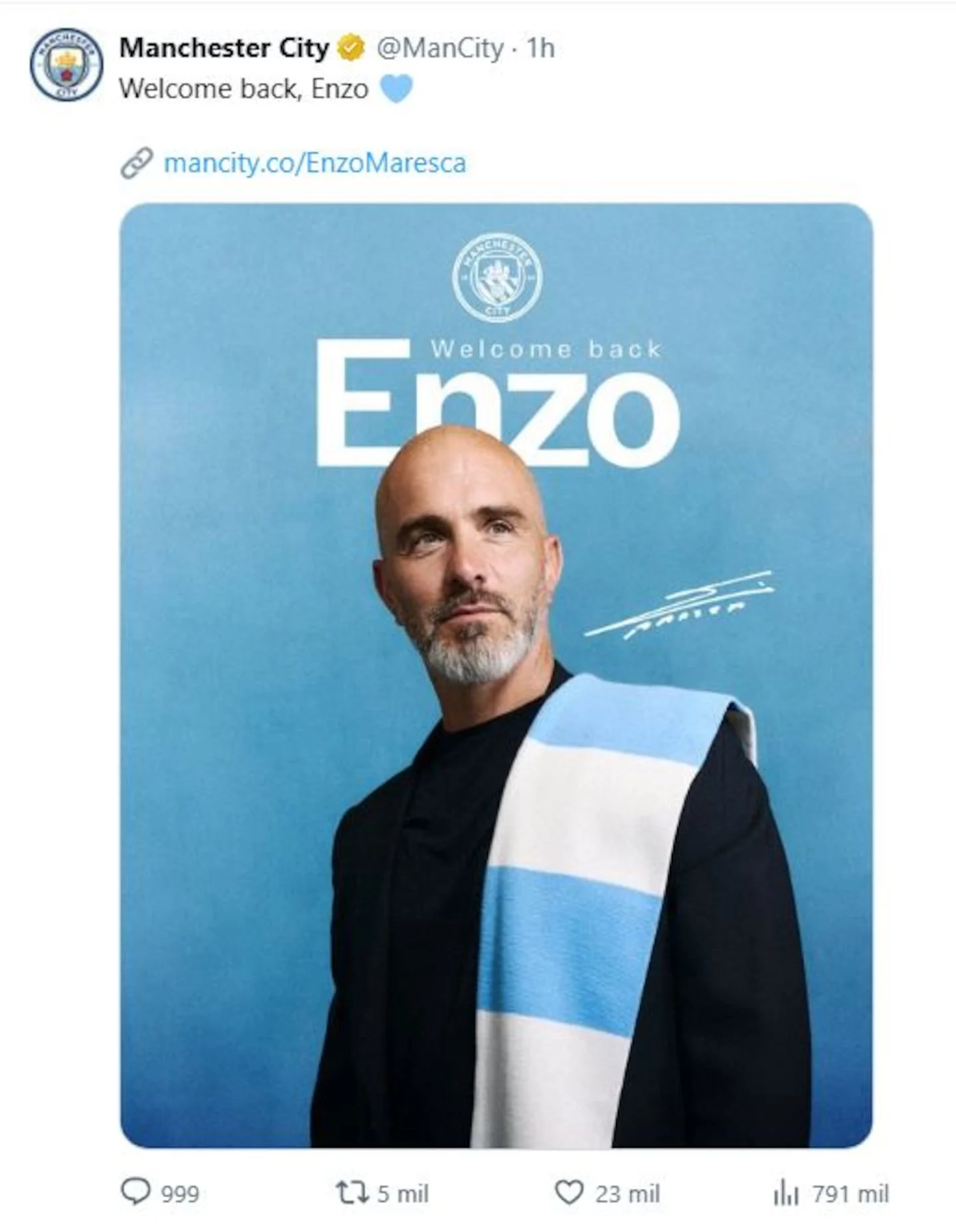 Enzo Maresca posando con una bufanda del Manchester City en un fondo azul