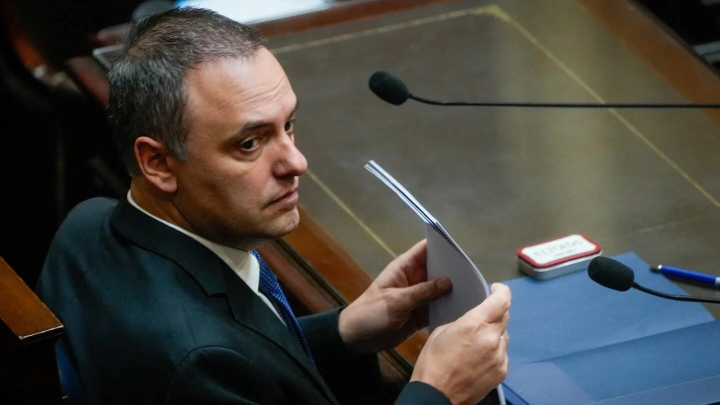Manuel Adorni en una sesión legislativa sosteniendo documentos