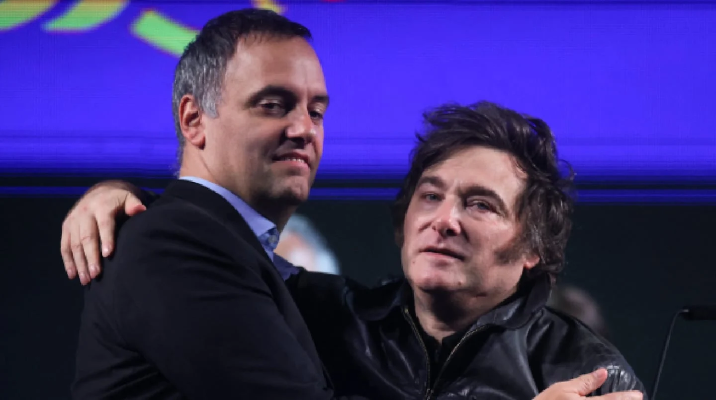 Manuel Adorni y Javier Milei en un evento público abrazados