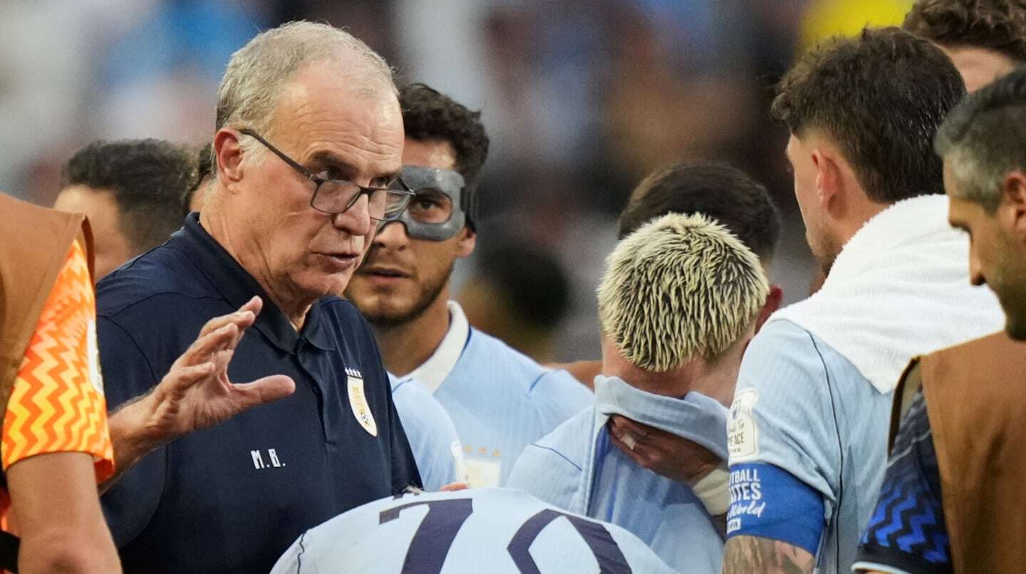Marcelo Bielsa discutiendo con jugadores de Uruguay durante una pausa de hidratación