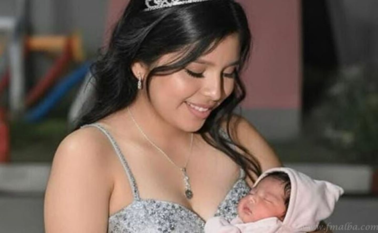 Mariana Aranda sostiene a su bebé en brazos, sonriendo con una tiara en la cabeza