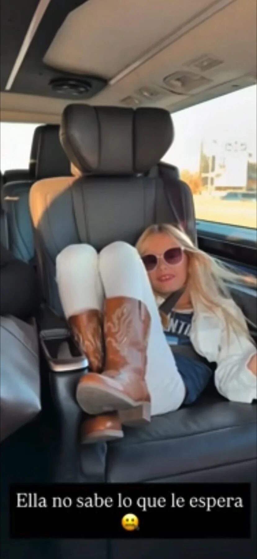 Matilda Salazar relajada en un asiento de auto, con botas y gafas de sol