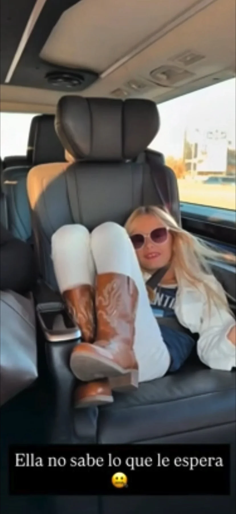 Matilda Salazar relajada en un asiento de auto, con botas y gafas de sol
