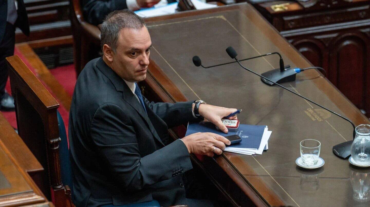 Manuel Adorni sentado en un escritorio durante una sesión legislativa