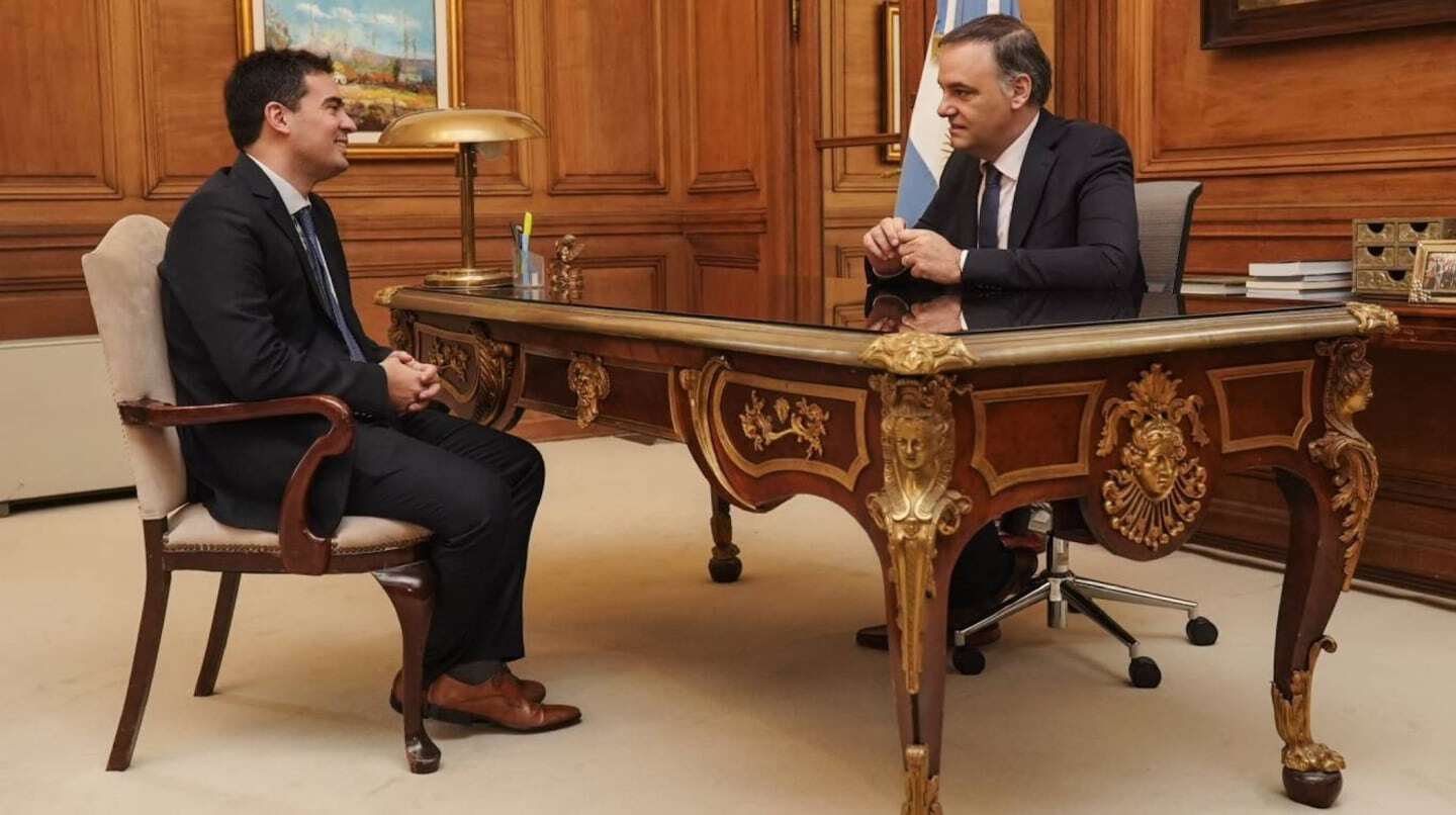 Javier Milei y Adrián Ravier conversando en una oficina elegante
