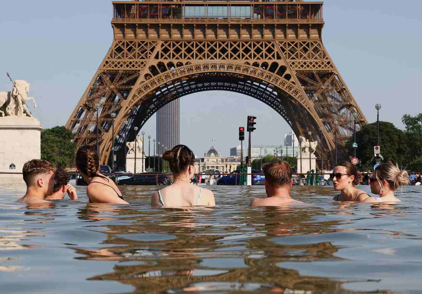 Grupo de personas en el agua frente a la Torre Eiffel durante una ola de calor en Francia