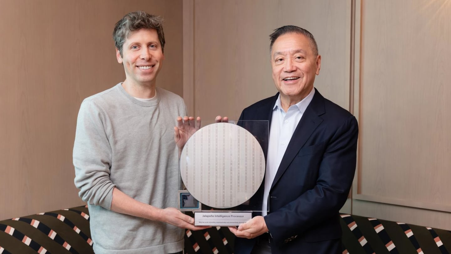 Dos hombres sosteniendo un trofeo que representa el chip Jalapeño de OpenAI