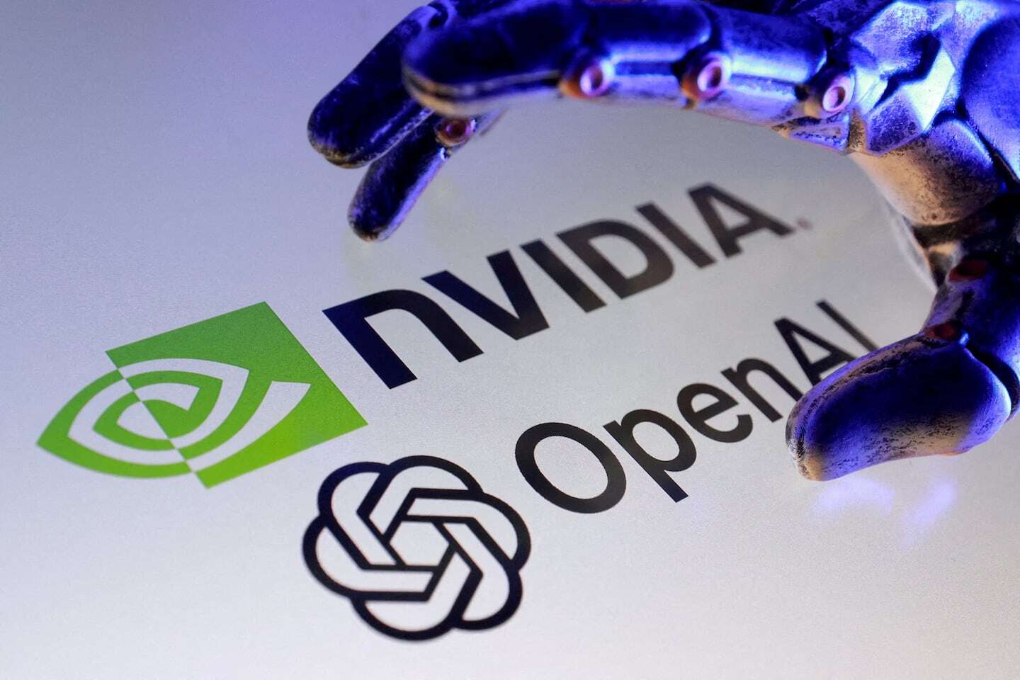 Logos de NVIDIA y OpenAI con una mano robótica en primer plano