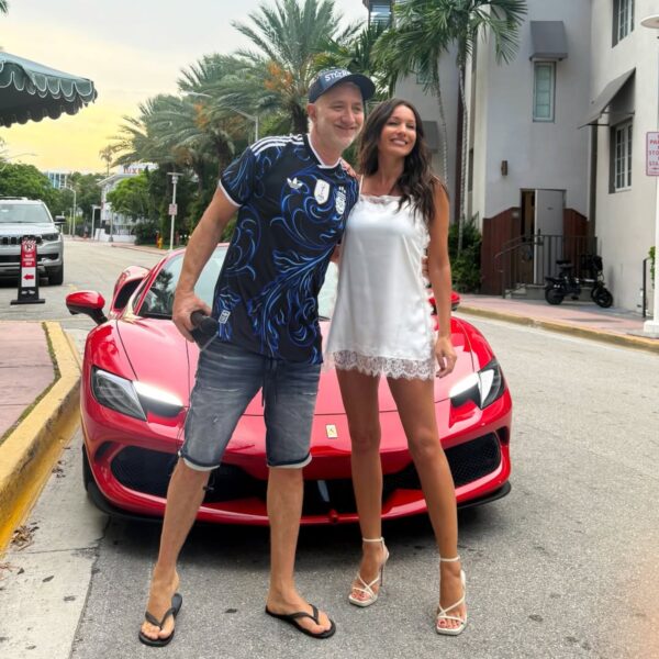 Pampita y Noelia Marzol posan frente a un auto deportivo rojo en una calle con palmeras