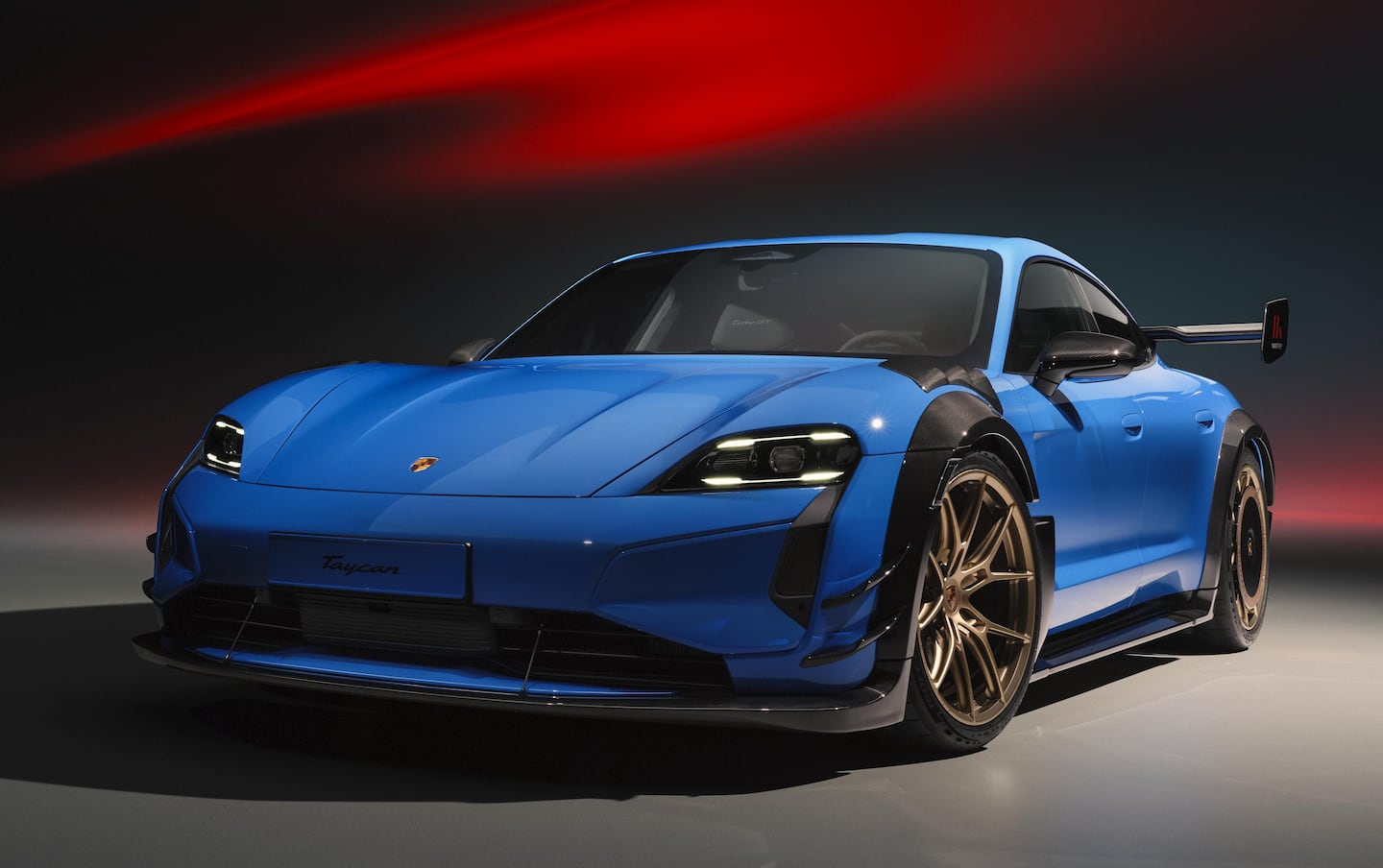 Porsche Taycan 2027 en color azul con diseño deportivo y llantas doradas