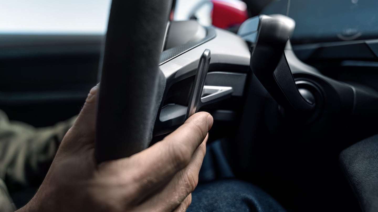 Mano ajustando el volante del Porsche Taycan 2027