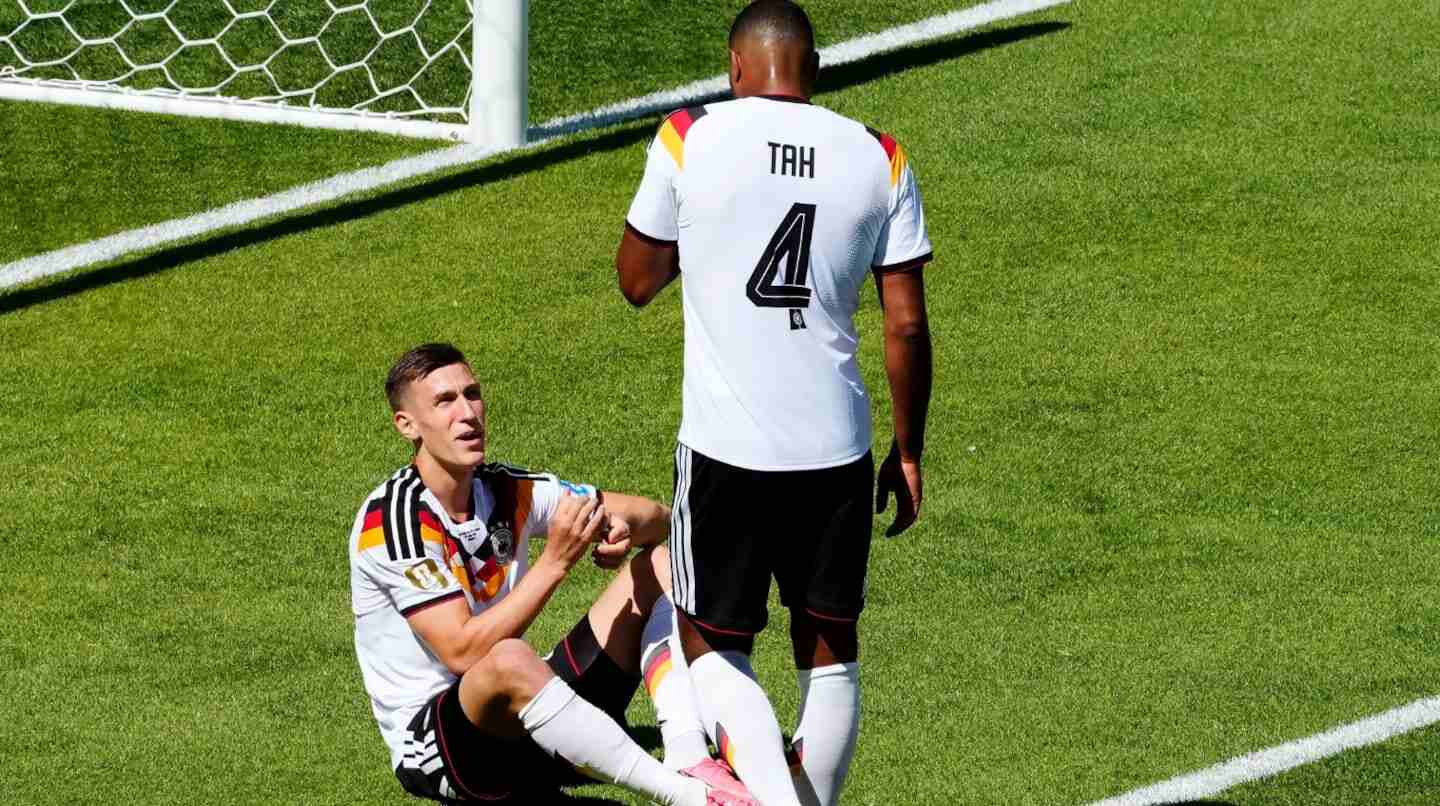 Nico Schlotterbeck sentado en el campo tras sufrir una lesión durante el partido contra Costa de Marfil