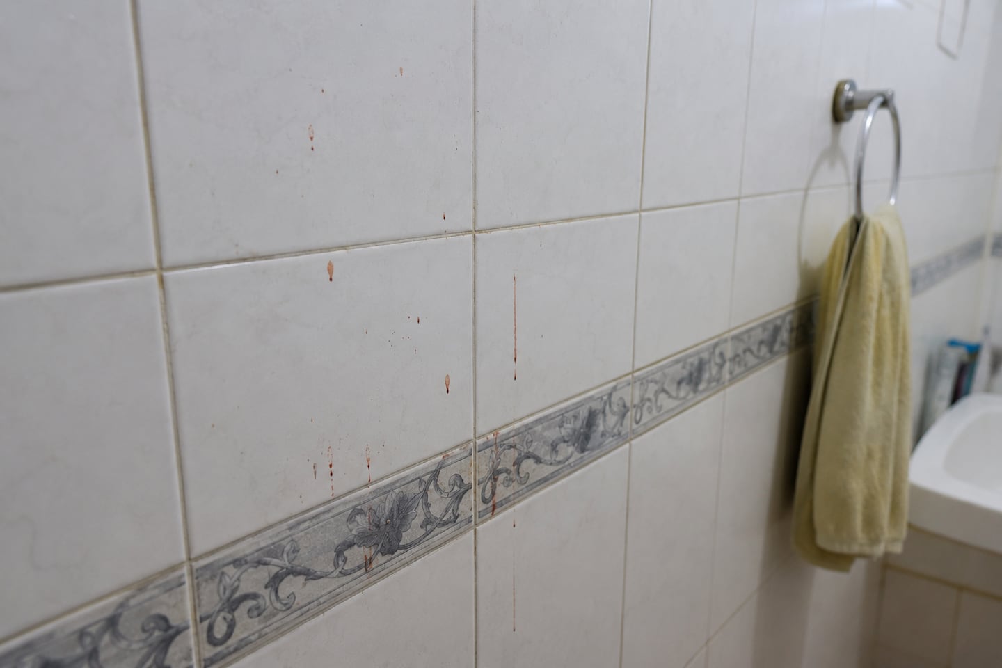 Baño con manchas de sangre en las paredes, evidenciando un femicidio